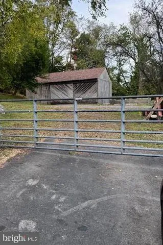 a view of backyard with wooden fence and large trees