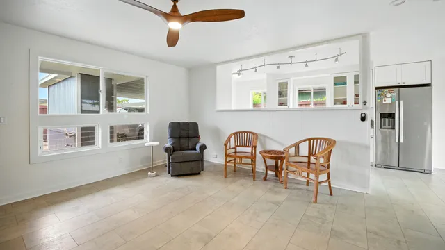 a living room with couches a fireplace and a dining table with wooden floor