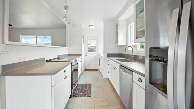 a kitchen with granite countertop a sink stove and cabinets