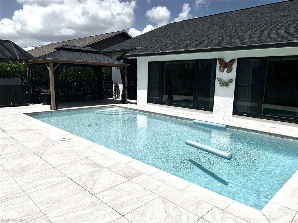 1344 Monarch Circle Naples, FL 34116 - Photo 19 of 33 a view of swimming pool with a bench in front of room