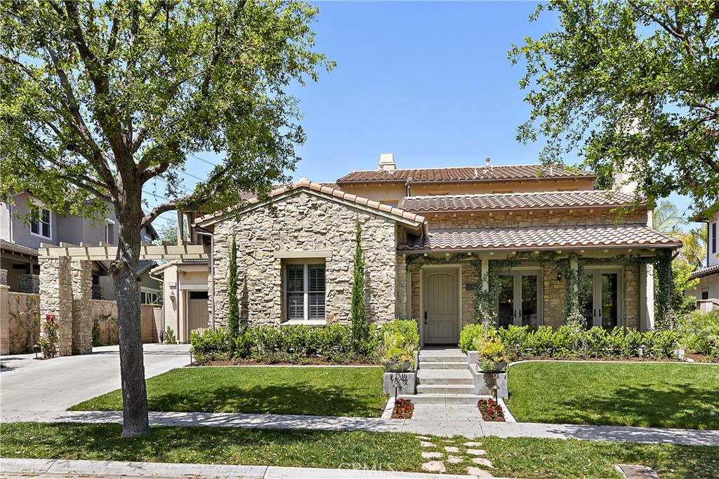 a front view of a house with a yard and potted plants