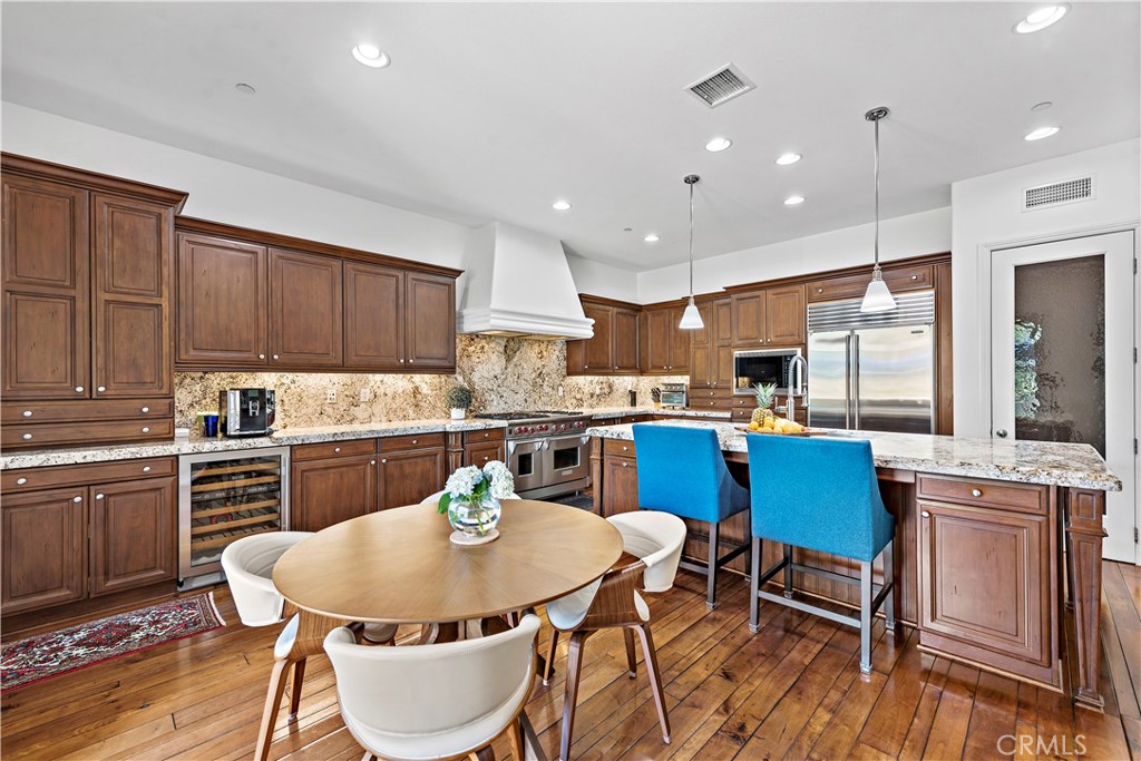 11 Pisano Street Ladera Ranch, CA 92694 - Photo 15 of 47 a kitchen with stainless steel appliances kitchen island granite countertop a kitchen island a stove a table and chairs