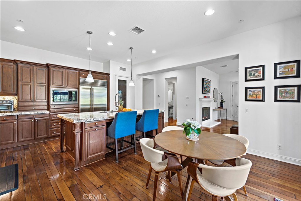 11 Pisano Street Ladera Ranch, CA 92694 - Photo 16 of 47 a kitchen with granite countertop a dining table chairs and refrigerator
