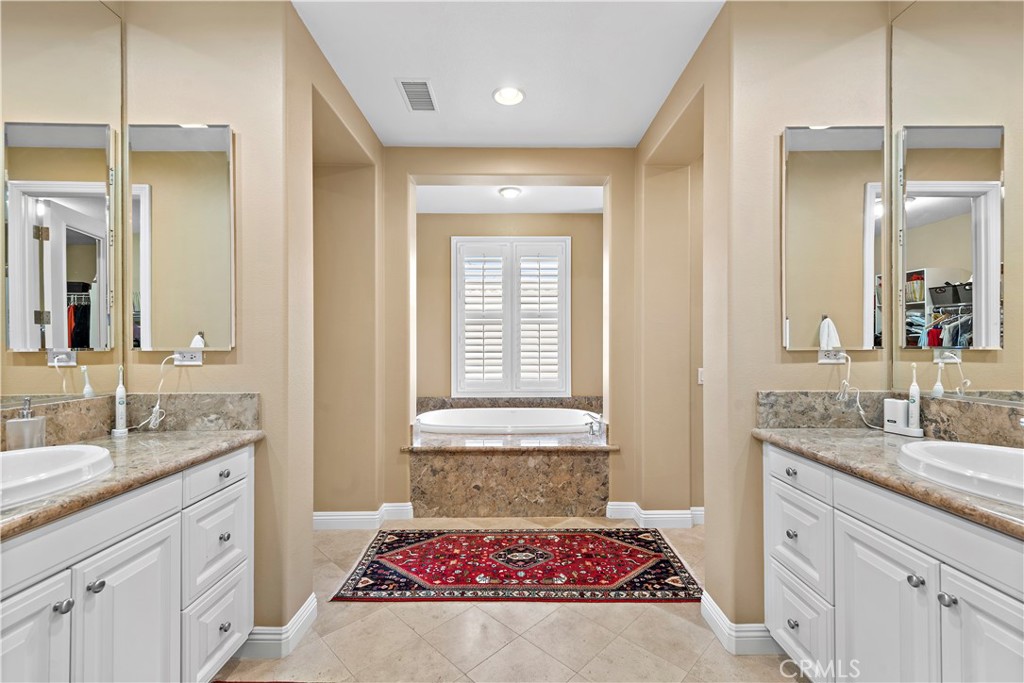 11 Pisano Street Ladera Ranch, CA 92694 - Photo 26 of 47 a bathroom with a granite countertop sink a mirror a vanity and a bathtub