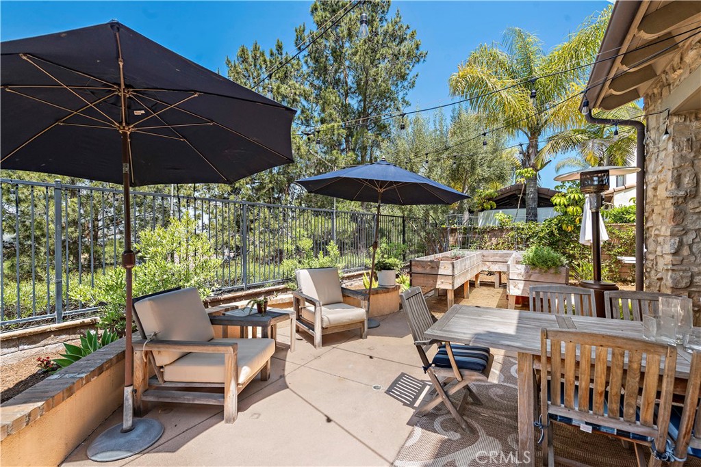 11 Pisano Street Ladera Ranch, CA 92694 - Photo 39 of 47 a view of a patio with a table and chairs under an umbrella
