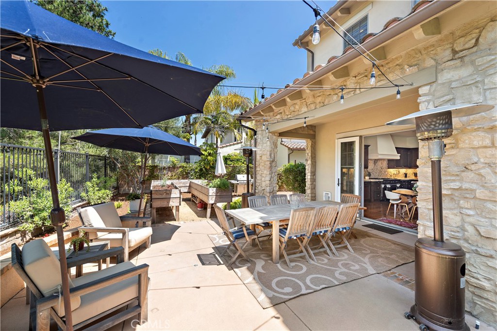 11 Pisano Street Ladera Ranch, CA 92694 - Photo 40 of 47 a view of a patio with table and chairs under an umbrella