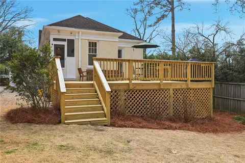 a view of a house with a wooden fence and a big yard