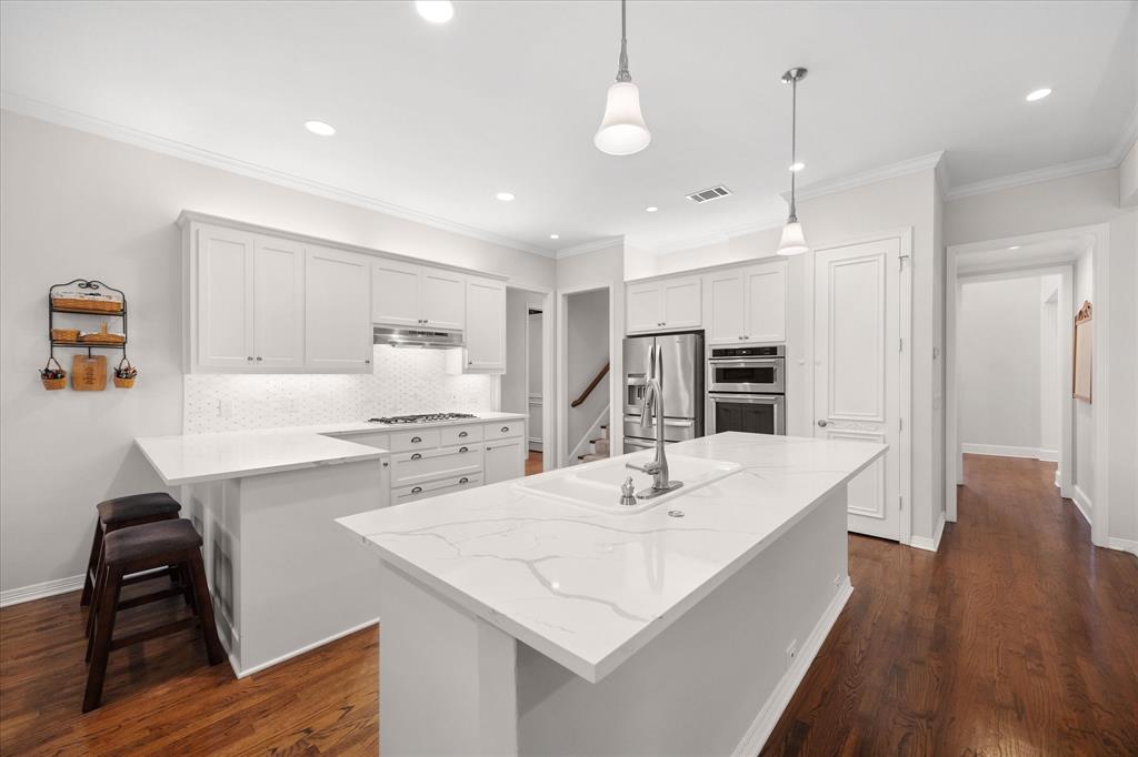 506 Meadowview Road Heath, TX 75032 - Photo 13 of 32 a large kitchen with kitchen island a stove a sink a dining table and chairs with wooden floor