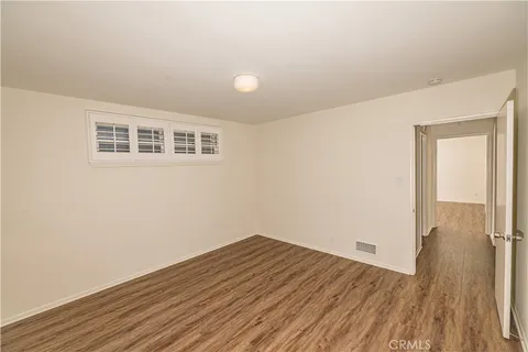 a view of a room with wooden floor and a window