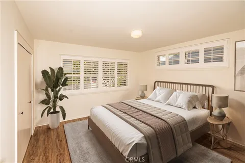a view of a bedroom with a large window and a wooden floor