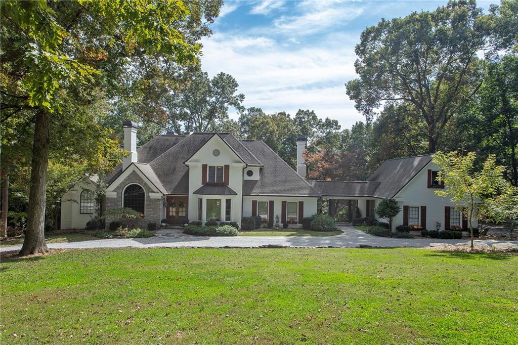 Classic French Country Farmhouse nestled among 3 private acres in downtown Roswell..pervious gravel drive true to the French farmhouse style and eco conscious..