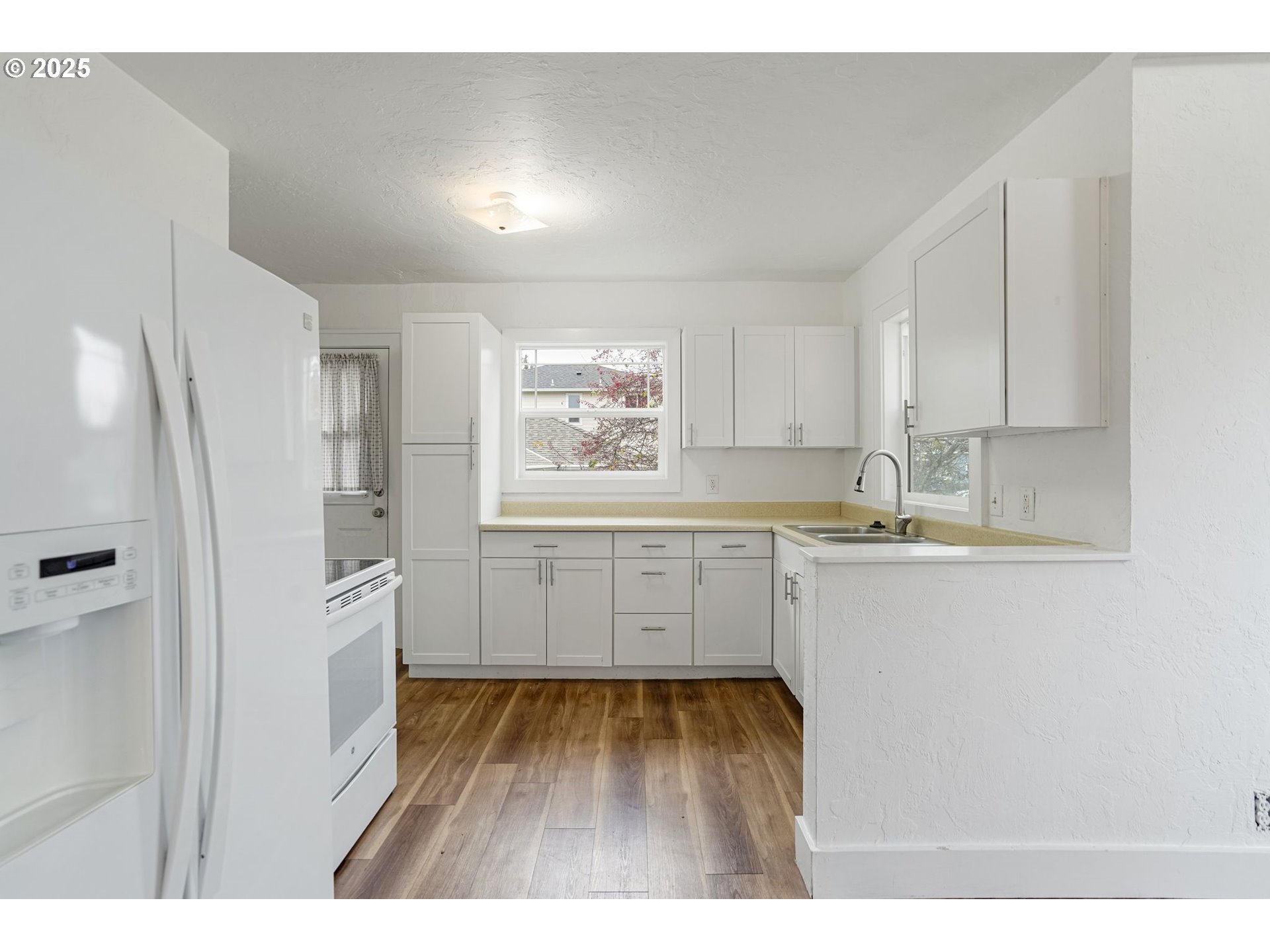 562 21st Street Northeast Salem, OR 97301 - Photo 11 of 45 a kitchen with white cabinets and wooden floor