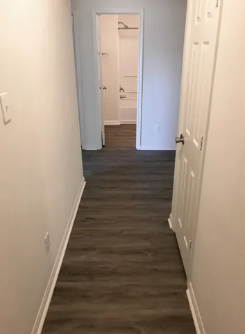 a view of a hallway with wooden floor and staircase