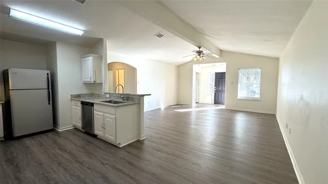 a view of a kitchen with a sink and a refrigerator
