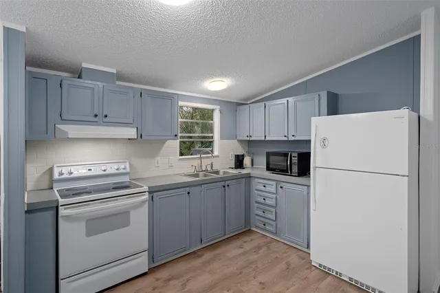 a kitchen with a sink a stove a refrigerator and cabinets