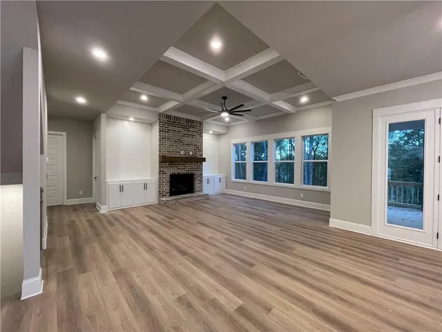 a view of an empty room with a window and fireplace
