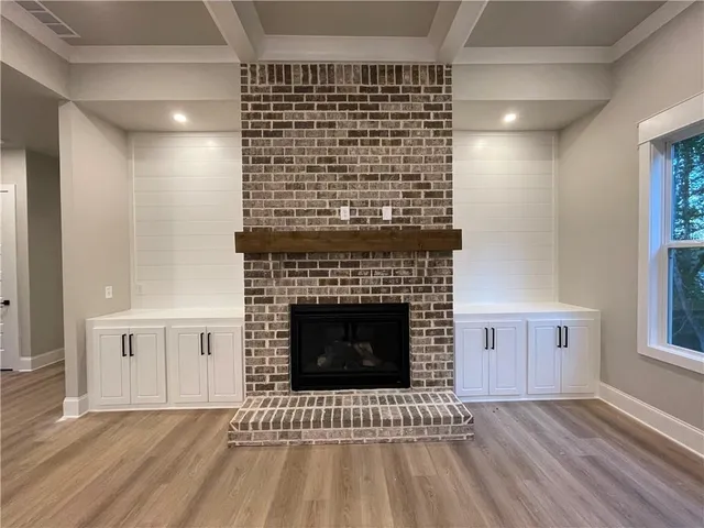 a view of empty room with wooden floor and fireplace