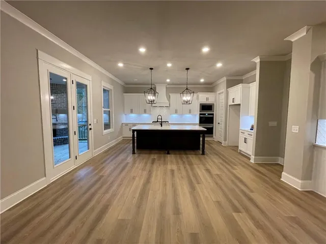 a kitchen with stainless steel appliances kitchen island granite countertop a refrigerator and a sink