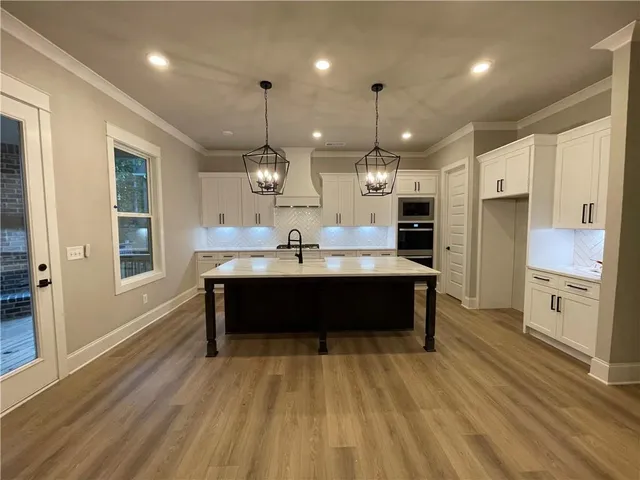 a large kitchen with kitchen island a sink stainless steel appliances and cabinets
