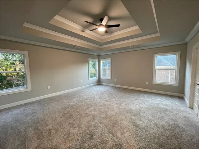 an empty room with windows and ceiling fan