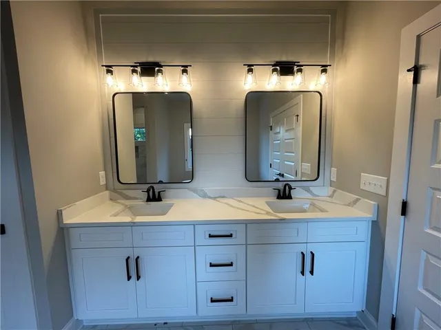 a bathroom with double vanity sinks and a mirror