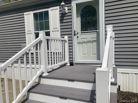 1661 Old Country Road, Unit 49 Riverhead, NY 11901 - Photo 2 of 11 a view of a balcony with door and wooden floor