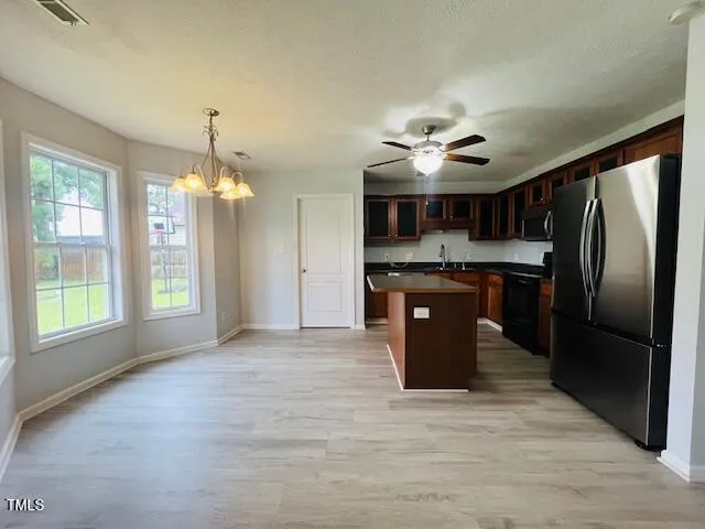 a kitchen with stainless steel appliances granite countertop a sink a stove and a refrigerator