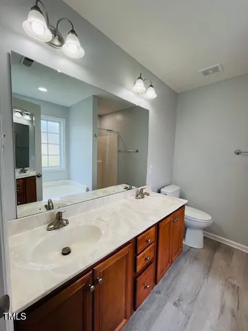 a spacious bathroom with a double vanity sink and a mirror