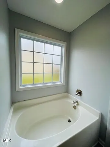 a white bath tub sitting next to a window