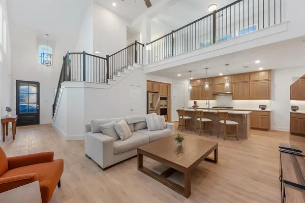 a living room with furniture kitchen view and a wooden floor