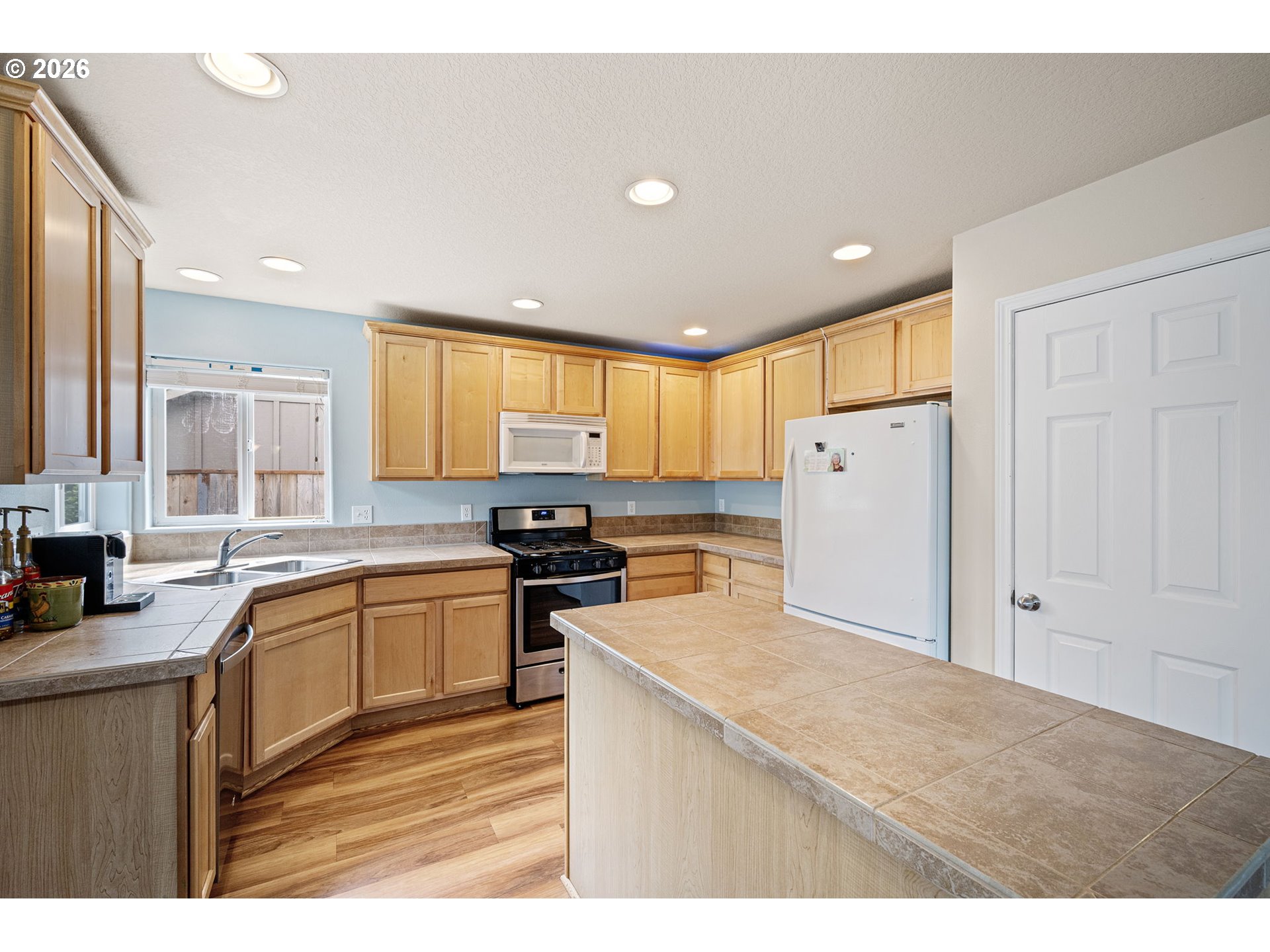 265 Southeast Casting Street Albany, OR 97322 - Photo 12 of 48 a kitchen with granite countertop a refrigerator stove top oven and sink