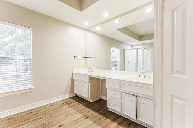 a spacious bathroom with a double vanity sink a mirror and a shower