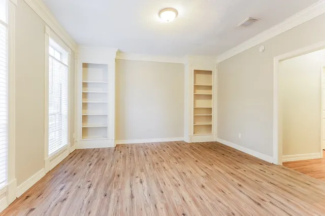 a view of empty room with wooden floor and entryway