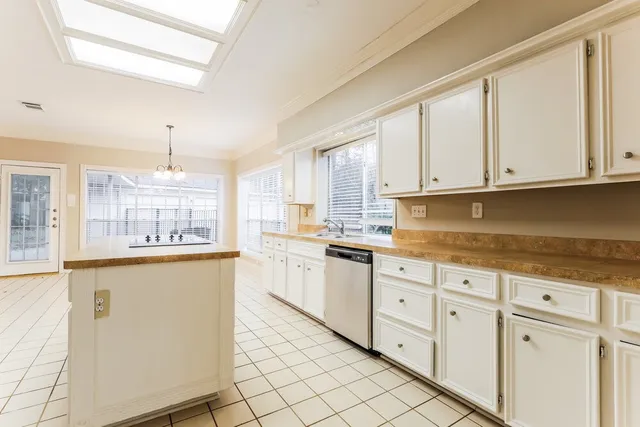 a kitchen with granite countertop white cabinets white appliances a sink and a window