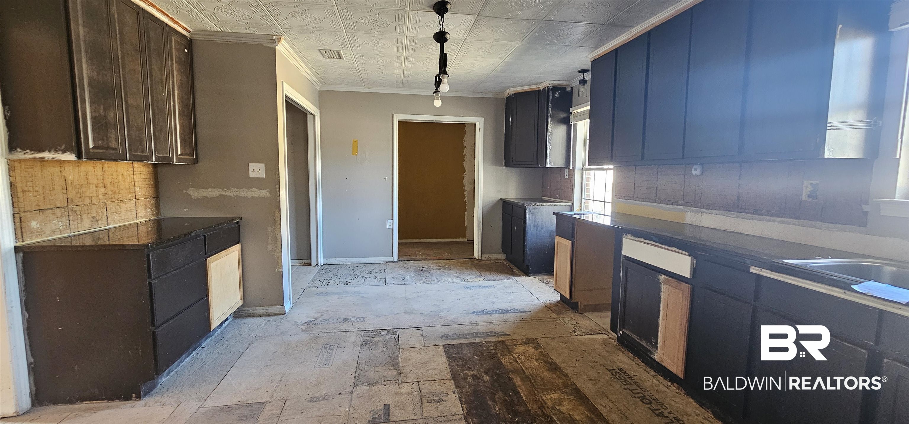 151 Bullard Street Atmore, AL 36502 - Photo 19 of 38 Kitchen featuring dark countertops, an ornate ceiling, ornamental molding, and pendant lighting