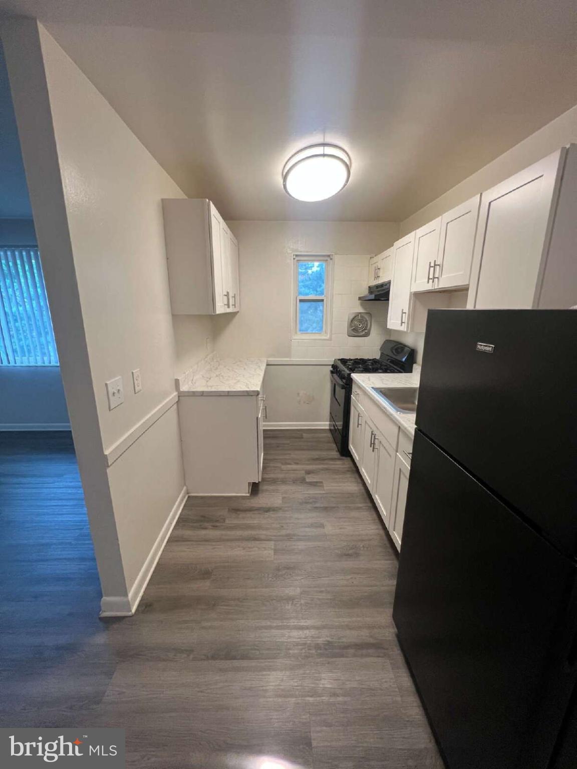 14404 Gemstone Drive, Unit 302 Woodbridge, VA 22191 - Photo 5 of 16 a kitchen with a sink a refrigerator a stove top oven and wooden floor