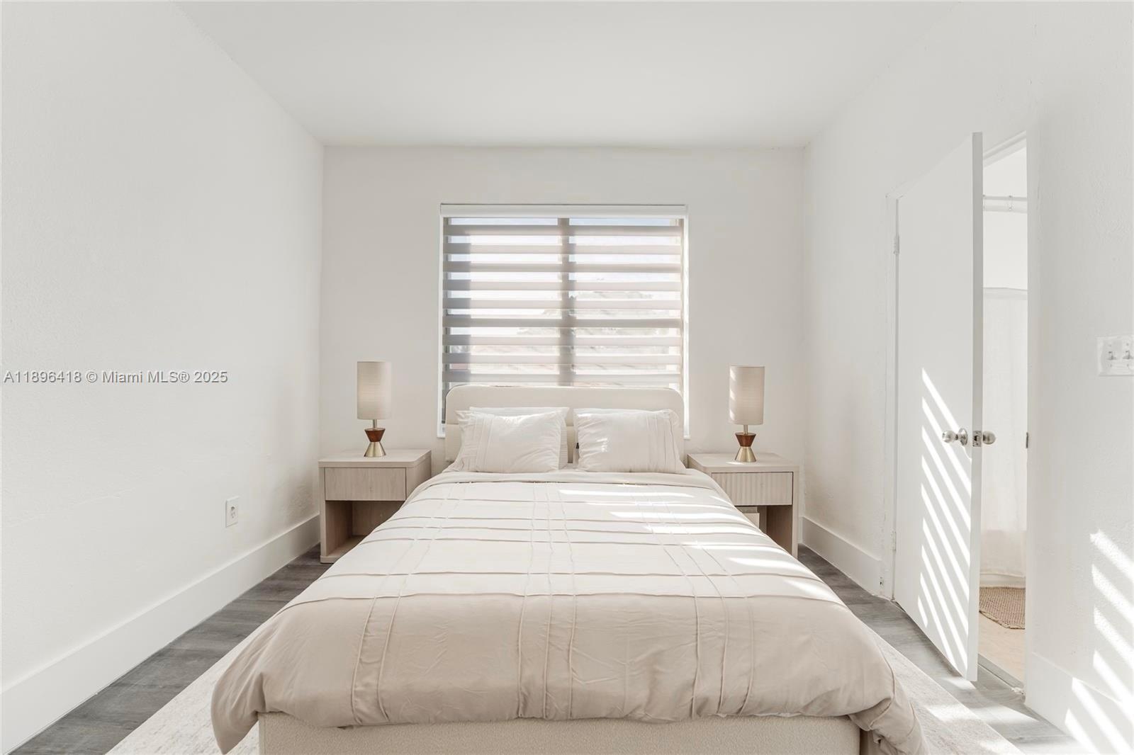 301 Southwest 10th Avenue, Unit 8 Miami, FL 33130 - Photo 11 of 14 a large white bed in a small room next to a window