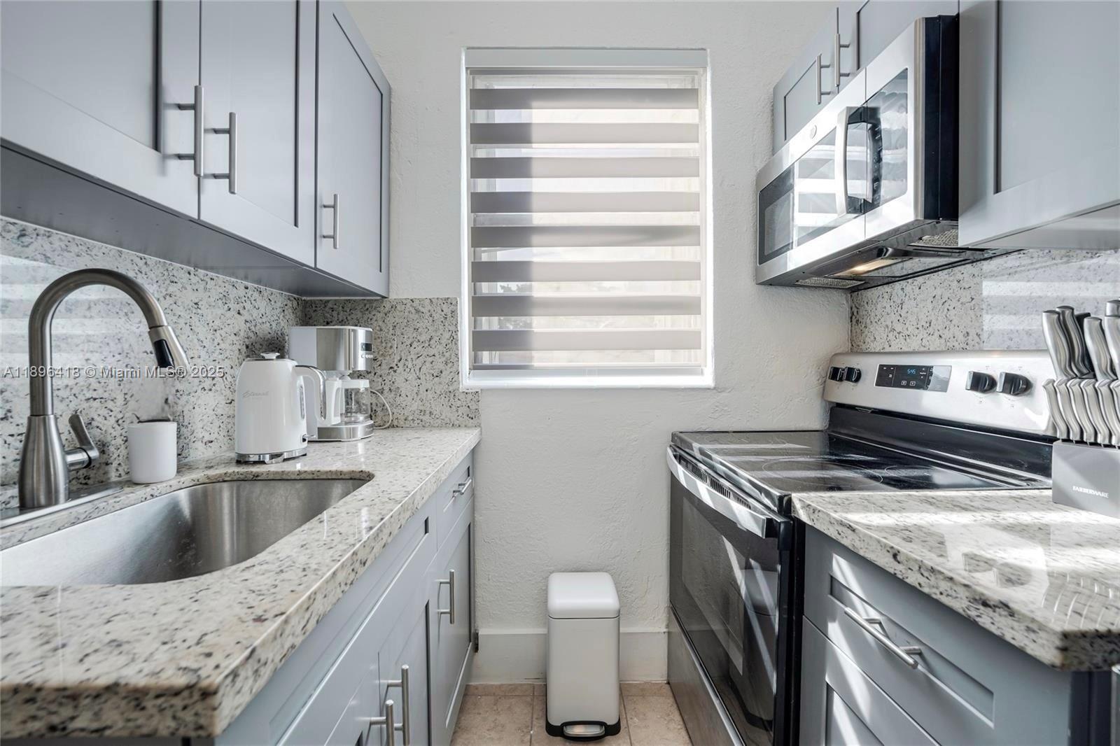 301 Southwest 10th Avenue, Unit 8 Miami, FL 33130 - Photo 3 of 14 a kitchen with stainless steel appliances granite countertop a sink stove and cabinets