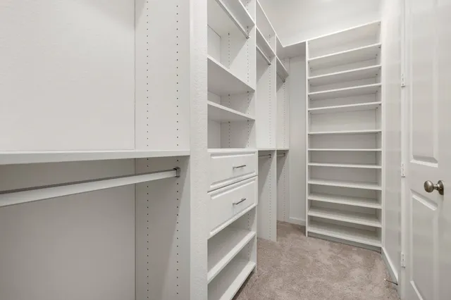a view of walk in closet with empty racks