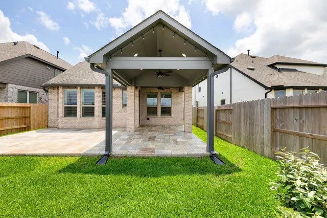 a backyard of a house with lots of green space and fountain