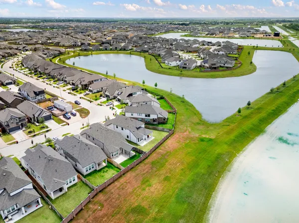 an aerial view of a house with a garden and lake view