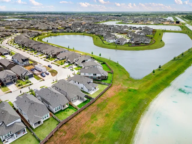 an aerial view of a house with a garden and lake view
