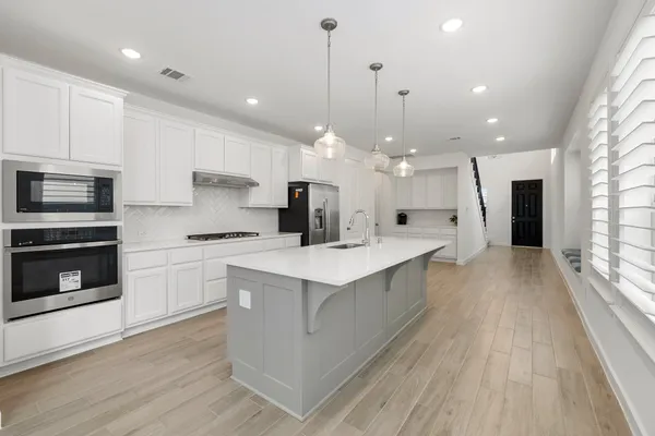 a kitchen with stainless steel appliances a sink stove and cabinets