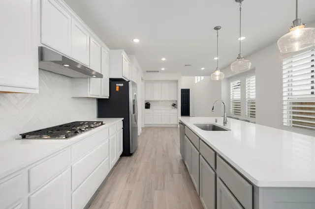 a view of a kitchen with wooden floor and electronic appliances