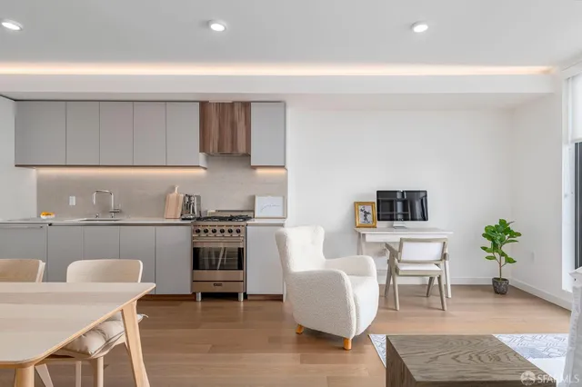 a living room with furniture a flat screen tv and a table