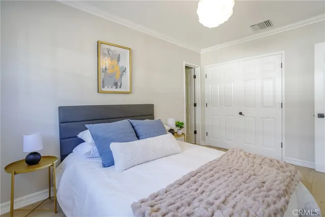 a bedroom with a bed and painting on the wall