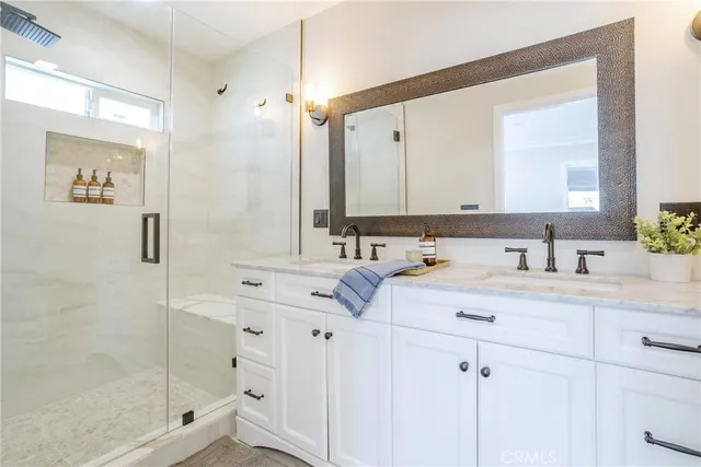 a bathroom with double vanity sink and a mirror