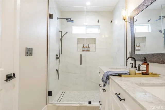 a bathroom with a granite countertop sink a shower and mirror