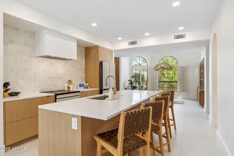 a dining hall with stainless steel appliances granite countertop a sink a stove and a refrigerator