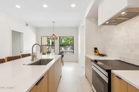 a kitchen with a sink a stove and cabinets